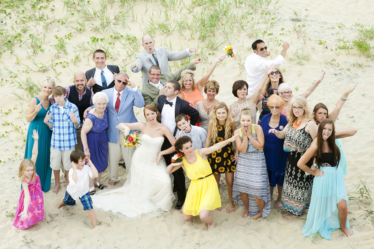 fun, stress-free OBX Wedding Photographer captures nontraditional portrait on the beach of bride and groom having fun with their family